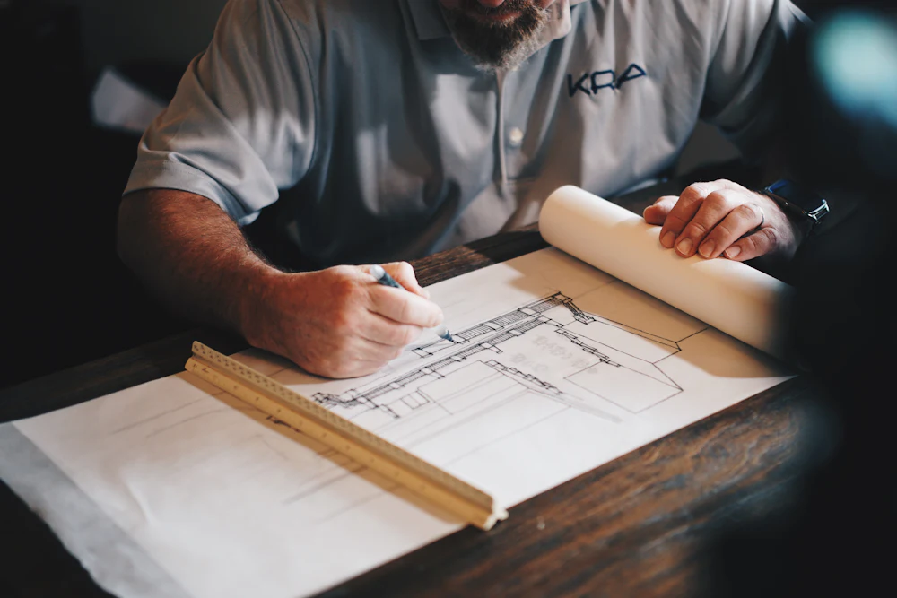 Engineer reviewing structural drawings at a drafting desk